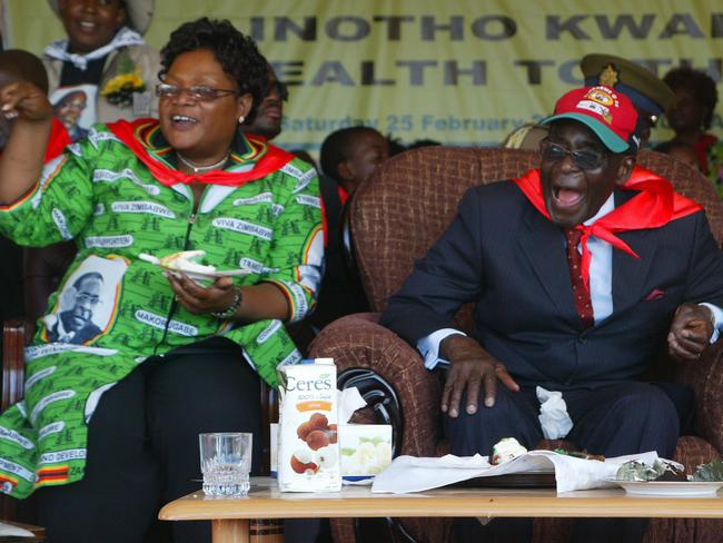 Party time ... Zimbabwe's President Robert Mugabe (right) and Vice President Joice Mujuru eat cake at Mugabe's 88th birthday in Mutare in 2012. Picture: Supplied