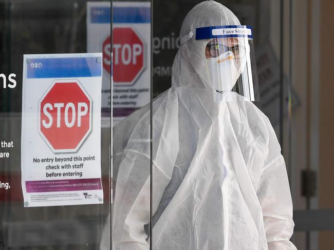 Medical workers speak at the entrance of the Epping Gardens aged care facility in the Melbourne suburb of Epping on July 29, 2020, as the city battles fresh outbreaks of the COVID-19 coronavirus. - Australia on July 30 reported a record number of new coronavirus infections and its deadliest day of the pandemic so far following a spike in cases at elderly care homes. (Photo by William WEST / AFP)
