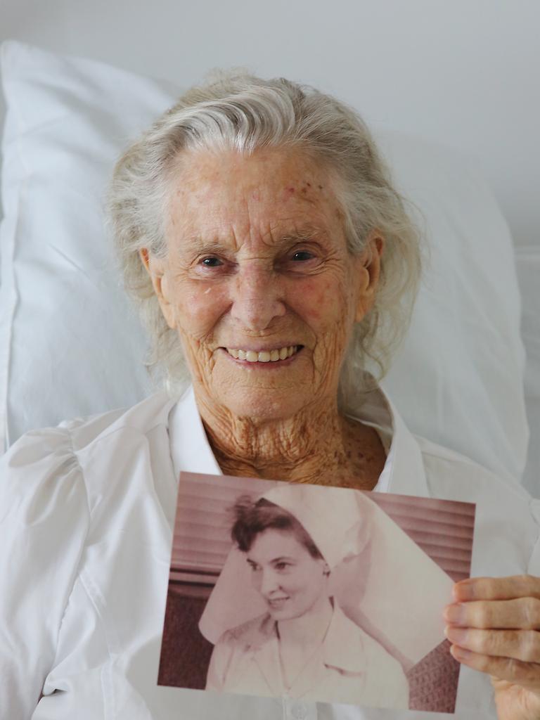 Venerable Adrienne Howley OAM, 90 has lead a full life. Now legally blind, she has been a nurse, sailed around the world and been endorsed as a Buddhist Lama by the Dalai Lama himself. Adienne Howley with an old photo of her in her nursing outfit. PICTURE: BRENDAN RADKE