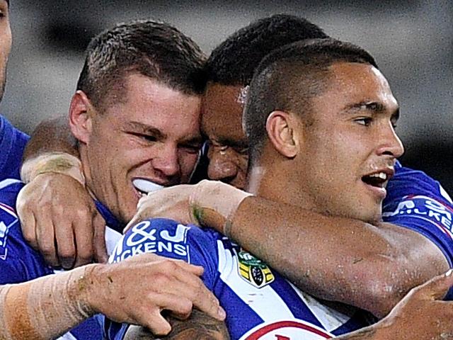 Kerrod Holland of the Bulldogs (centre) celebrates with team mates after scoring a try during the Round 20 NRL match between the Canterbury-Bankstown Bulldogs and the Wests Tigers at ANZ Stadium in Sydney, Friday, July 27, 2018. (AAP Image/Dan Himbrechts) NO ARCHIVING, EDITORIAL USE ONLY