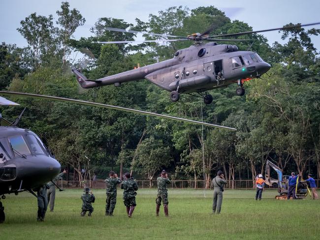 The Thai air force carry a mini excavator to the site where a soccer team and their coach went missing. Picture: Getty Images