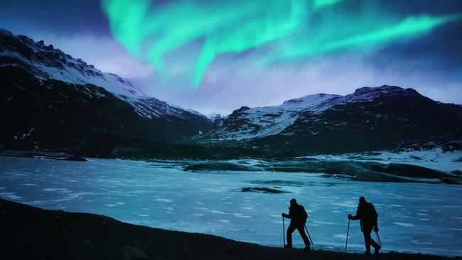 Hikers under the northern lights in Iceland