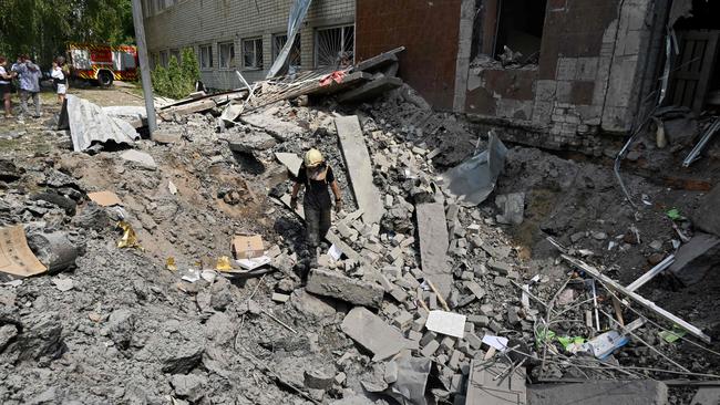 A rescuer walks in a crater in the ruins of a school building partially destroyed by two rockets in the Ukrainian city of Kharkiv on June 28, 2022. Picture: AFP