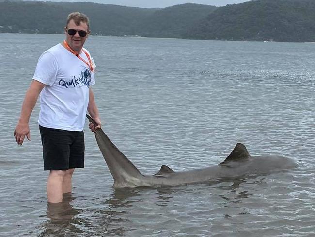 A man pulls a dead shark to shore at Pittwater. It follows a weekend of heavy rain and winds. Picture: Jac Shell.