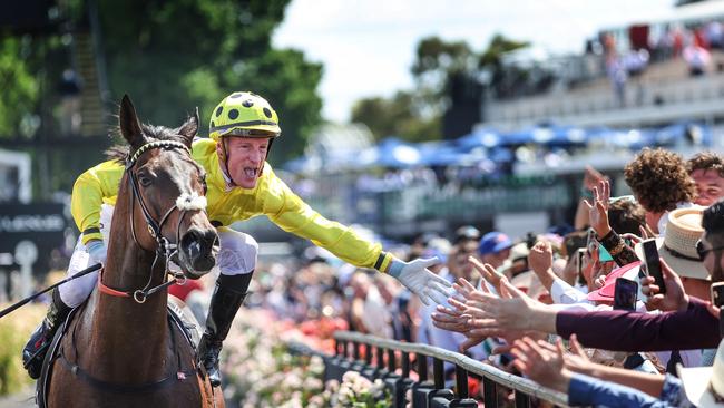 Winning jockey Mark Zahra high fives the crowd on Melbourne Cup Day. Picture: David Caird