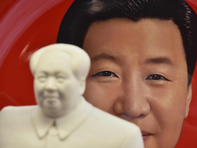 A decorative plate featuring an image of Chinese President Xi Jinping is seen behind a statue of late communist leader Mao Zedong at a souvenir store next to Tiananmen Square in Beijing. Picture: AFP