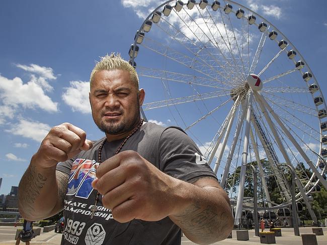 A mean looking Mark Hunt raises his fists.