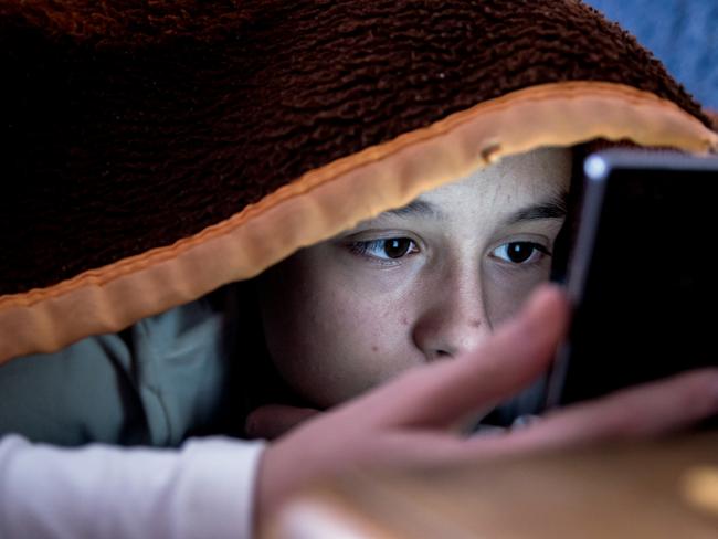 girl in bed texting on smartphone