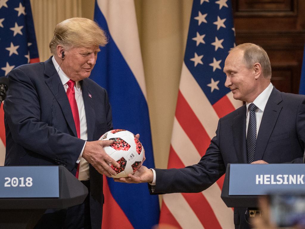 Russian President Vladimir Putin hands US President Donald Trump (L) a World Cup football during a joint press conference after their summit in Helsinki. Picture: Getty Images