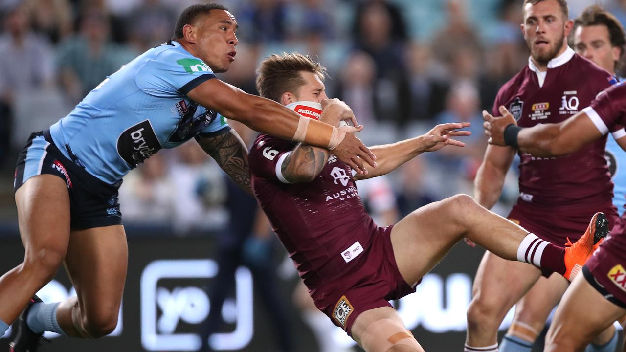 Cameron Munster of the Maroons and Tyson Frizell of the Blues compete for the ball in an incident that concussed the Queensland star.