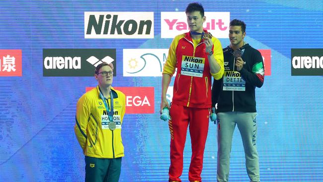 Mack Horton looks on from below the podium as gold medallist Sun Yang of China and bronze medallist Gabriele Detti of Italy pose during the medal ceremony. Picture: Maddie Meyer/Getty Images