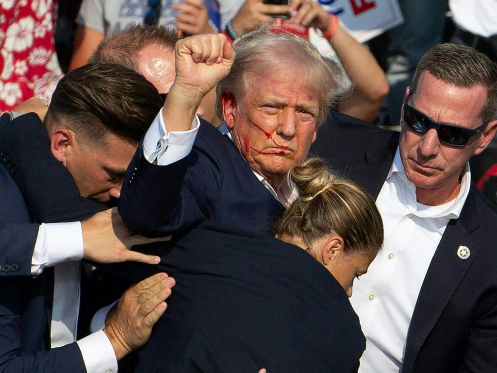 Donald Trump with blood on his face surrounded by secret service agents as he is taken off the stage at a campaign event in Pennsylvania on July 13. Picture: Rebecca Droke/AFP