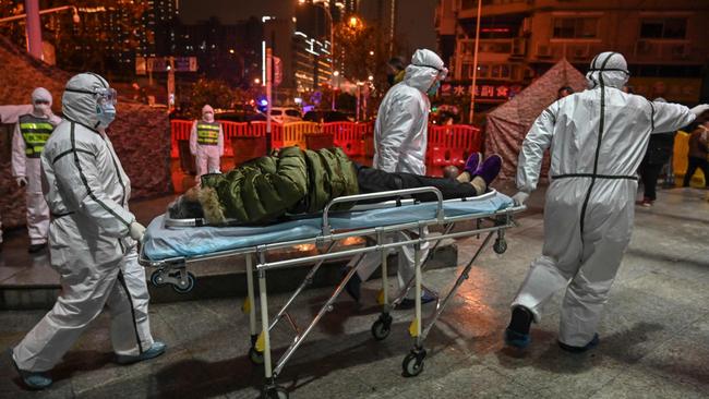 Chinese medical staff with a Covid-19 patient in Wuhan in January. Picture: AFP