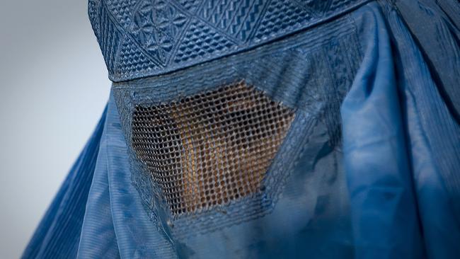 A woman under her burqa walking down a street in the old city of Kabul. Picture: AFP.