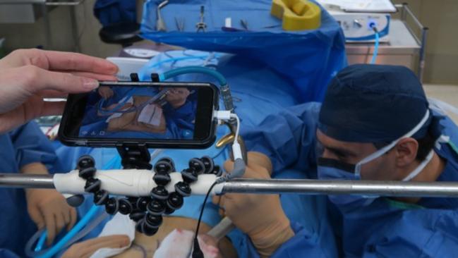 A nurse films while plastic surgeon Dr Eddy Dona performs a breast augmentation.