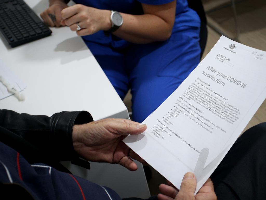 John Brown looks at a COVID-19 vaccine information pack ahead of receiving the COVID-19 AstraZeneca vaccine in Sydney. Picture: Lisa Maree Williams