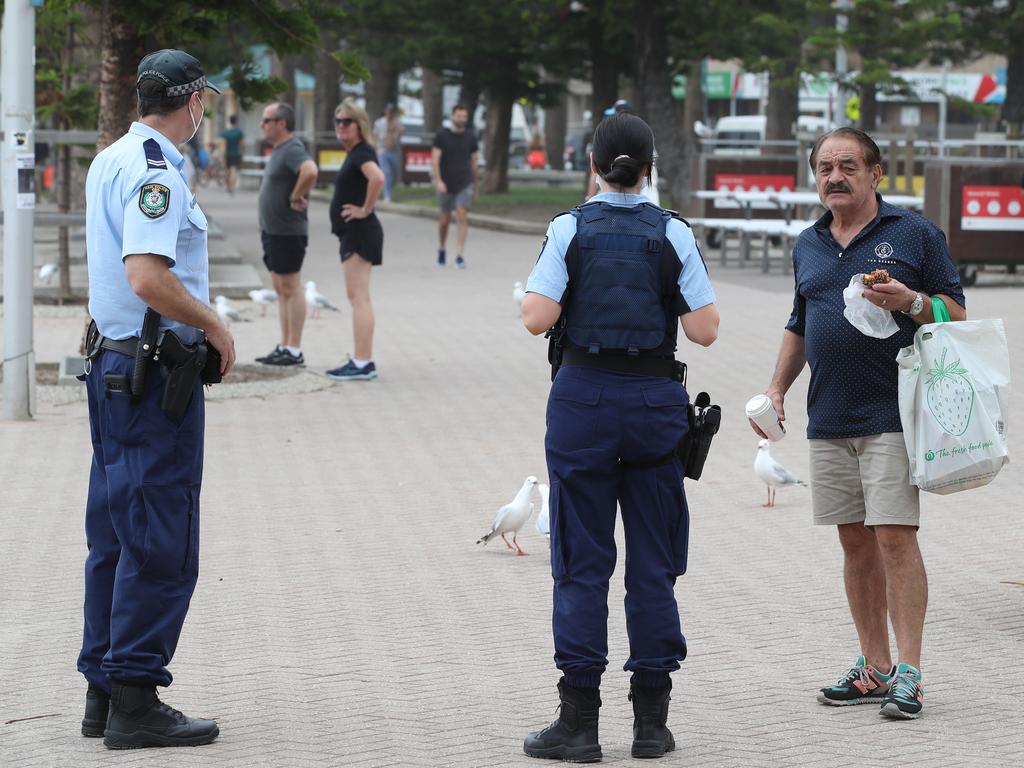 Police talk to locals in Manly where stay at home orders are in place. Picture: David Swift