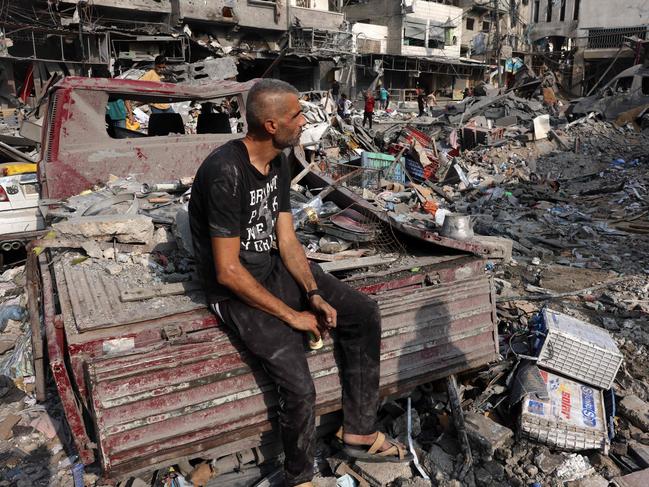 TOPSHOT - A man sits amid the destruction following Israeli strikes on Al-Shatee camp in Gaza City on October 28, 2023. Israeli air strikes destroyed hundreds of buildings in the Gaza Strip overnight, the civil defence service in the Hamas-controlled Palestinian territory said on October 28. (Photo by MOHAMMED ABED / AFP)