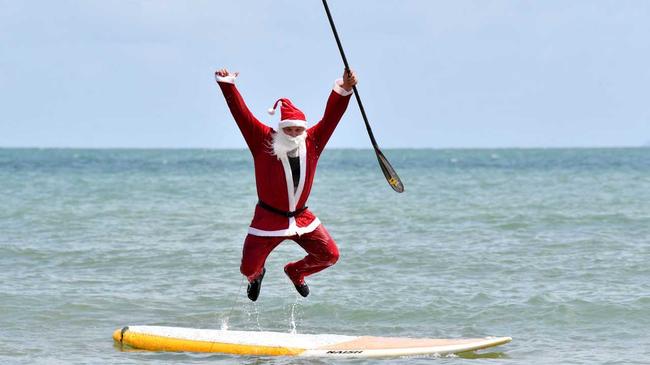 Santa (Ross Gee) has a dip at Eimeo Beach before Christmas. Picture: Tony Martin