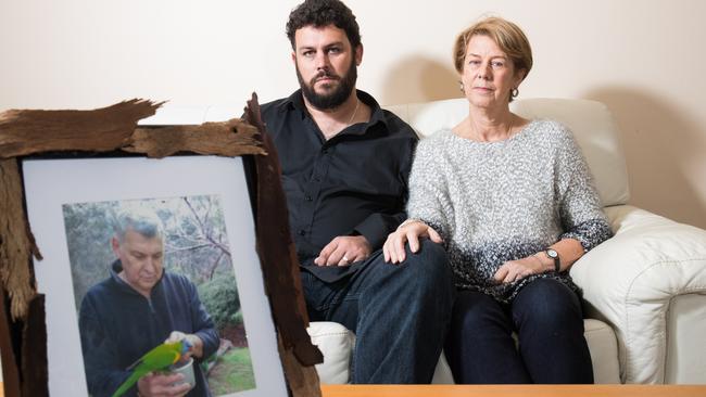 Clive and Barb Spriggs in their family home in Bellevue Heights with a photo of father and husband Bob Spriggs, who was mistreated at Oakden. Picture: Matt Loxton