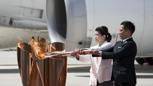 Olympic gold medalists Tadahiro Nomura, right, and Saori Yoshida light the Olympic flame at the Japan Air Self-Defence Force Matsushima Air Base in Matsushima, Miyagi. Picture: Getty Images