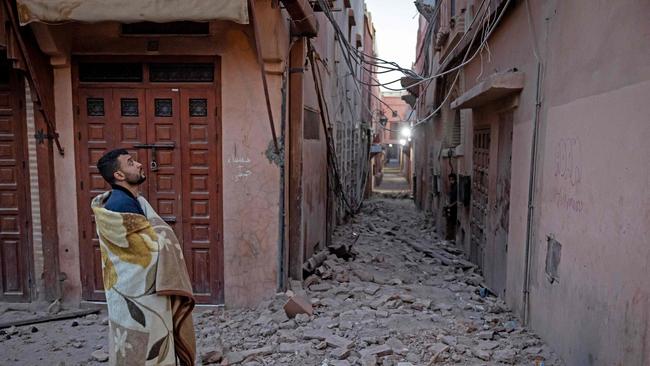 A resident looks at a damaged building. Picture: AFP