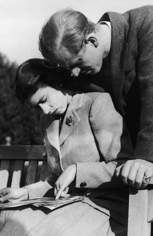 The couple look over their wedding photographs while on honeymoon in Romsey, Hampshire. Picture: Keystone/Hulton Archive/Getty Images