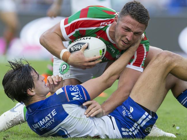 Lachlan Lewis of the Bulldogs tackles Sam Burgess of the Rabbitohs during the Round 6 NRL match between the South Sydney Rabbitohs and the Canterbury Bulldogs at ANZ Stadium in Sydney, Friday, April 19, 2019. (AAP Image/Craig Golding) NO ARCHIVING, EDITORIAL USE ONLY