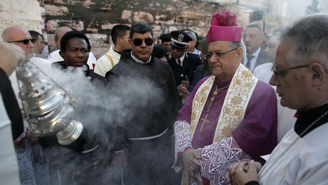 Peace ... The Latin Patriarch of Jerusalem Fuad Twal (C) greets worshippers outside the Church of the Nativity as Christians gather for Christmas celebrations in the West Bank city of Bethlehem, on Christmas Eve. Picture: AFP PHOTO/AHMAD GHARABLI