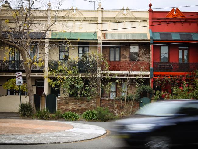 A car drives past a row of terrace houses in Sydney, Australia, on Tuesday, June 28, 2011. Australian home prices surged in the past two years, leaving the nation with the developed world's costliest homes, highest interest rates and among its most indebted households. Photographer: Ian Waldie/Bloomberg