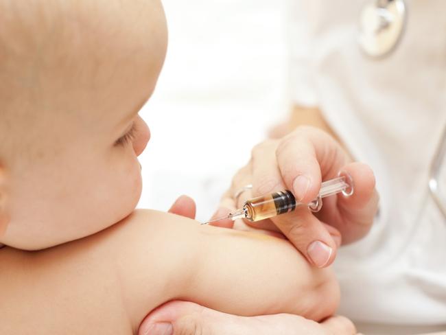 Doctor giving a child an intramuscular injection in arm, shallow DOF