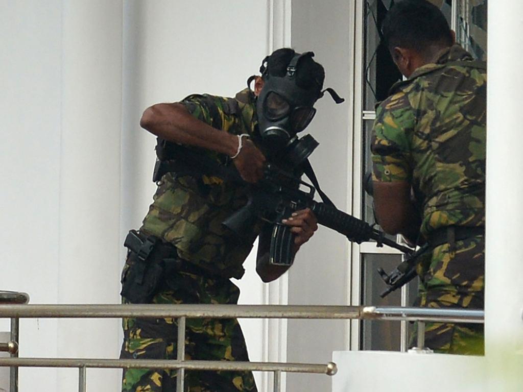 Sri Lankan Special Task Force (STF) personnel in gas masks outside a house during a raid after a suicide blast had killed police searching the property. Picture: AFP