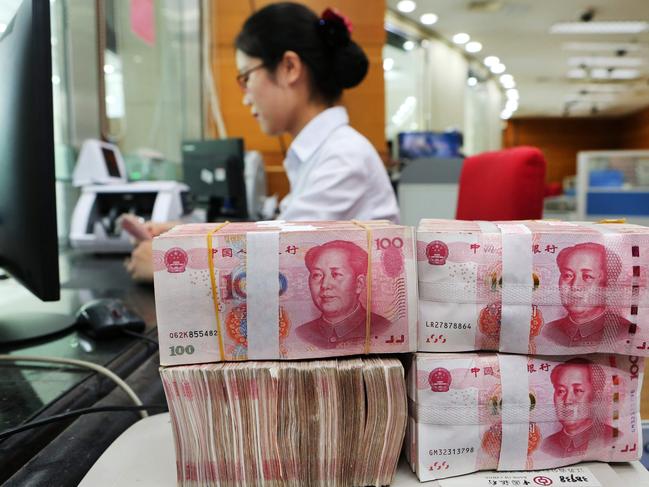 An employee counts 100-yuan notes at a bank in Nantong in China's eastern Jiangsu province on July 23, 2018.  China on July 23 rejected accusations by US President Donald Trump that it was manipulating the yuan to give its exporters an edge, saying Washington appeared "bent on provoking a trade war". / AFP PHOTO / - / China OUT