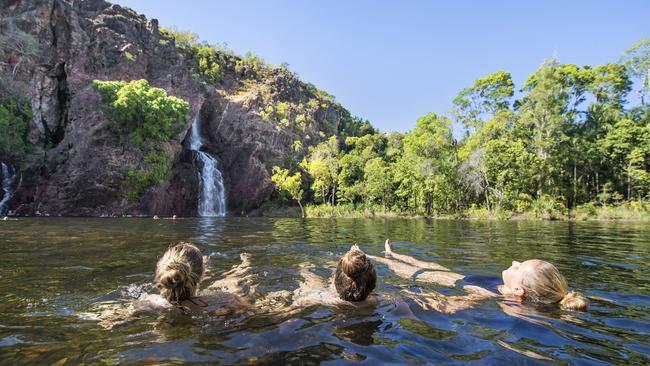 Tourists cool off at a waterfall in Litchfield National Park. Picture: Tourism NT