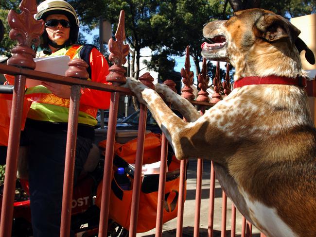 NEWS Postman Lesley Hudson wary of dog as he delivers mail in Zetland, Sydney. letter box post letter guard dog generic