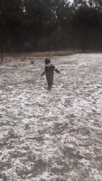 Young boy excited by snow falling in Queensland