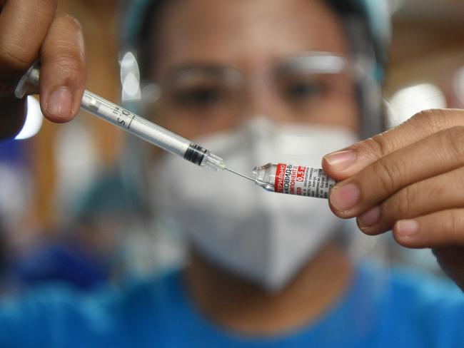 A health worker prepares a dose of Gamaleya National Center of Epidemiology and Microbiology's Sputnik V Covid-19 vaccine during a vaccination for residents in Mandaluyong City, suburban Manila on July 15, 2021. (Photo by Ted ALJIBE / AFP)