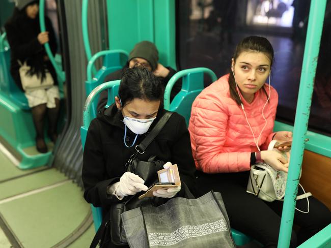 A train passenger protects herself with a mask in the Italian city of Milan. Picture: Getty Images