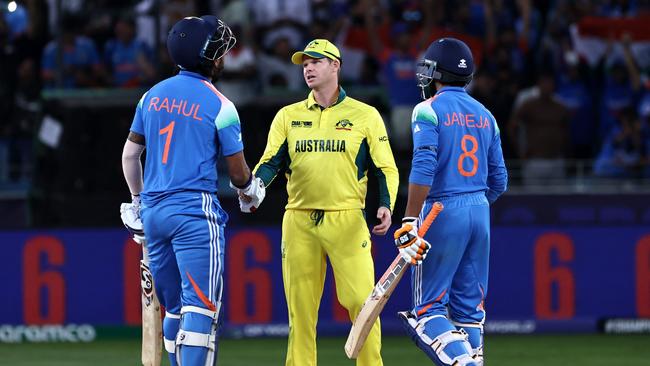 Australia's captain Steve Smith (C) shakes hands with India's KL Rahul as India's Ravindra Jadeja (R) watches at the end of the ICC Champions Trophy one-day international (ODI) semi-final cricket match between Australia and India at the Dubai International Stadium in Dubai on March 4, 2025. (Photo by FADEL SENNA / AFP)