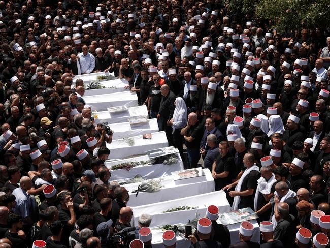 (FILES) Druze elders and mourners surround the coffins of 10 of the 12 people killed in a rocket strike from Lebanon a day earlier, during a mass funeral in the Druze town of Majdal Shams in the Israel-annexed Golan Heights, on July 28, 2024. Hamas's attack on October 7 resulted in the deaths of 1,205 people on the Israeli side, most of them civilians, according to an AFP tally based on Israeli official figures. Israel's retaliatory military campaign in Gaza has killed at least 41,431 Palestinians, the majority of them civilians, according to figures provided byÂ the health ministry in Hamas-run Gaza. The United Nations hasÂ acknowledged the toll as reliable. (Photo by Jalaa MAREY / AFP)