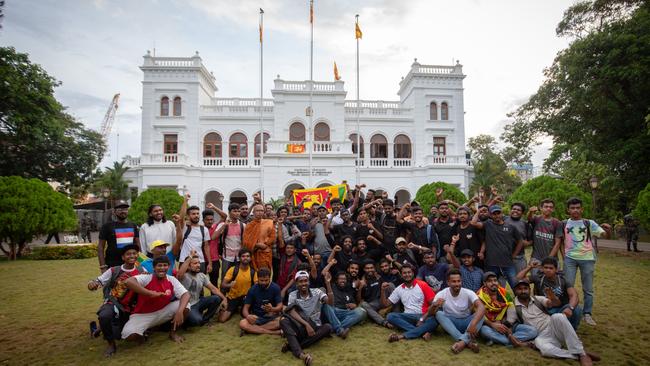 Protesters pose for a group photo as they return control of the seized Prime Minister's Office compound to government authorities on Thursday. Picture: Getty Images