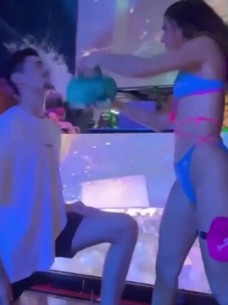 The Spring Break revellers take a shot from a glass held in Ms Callas’ mouth before getting a pitcher of water poured on their head and a slap to the face. Picture: Instagram/hurricaneaiyana