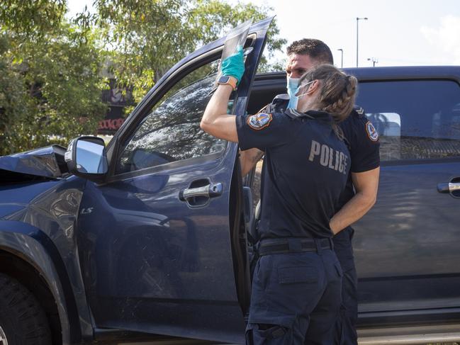 NT Police investigators work together to uncover identifiable information on the allegedly stolen Isuzu ute. Picture: Floss Adams.