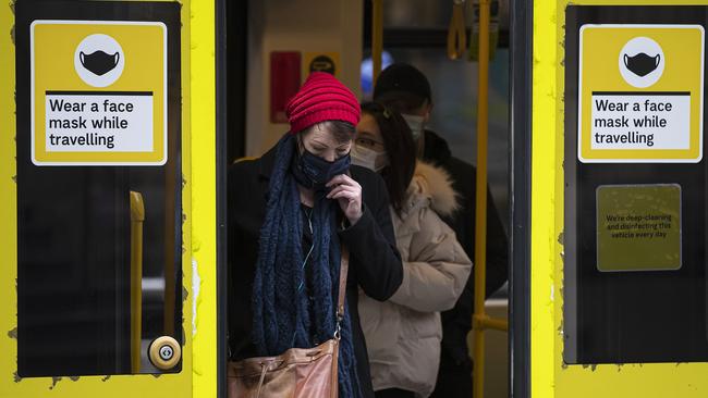 People wearing face masks disembark from a tram in Melbourne ahead of tonight’s midnight lockdown. Picture: Daniel Pockett/Getty Images