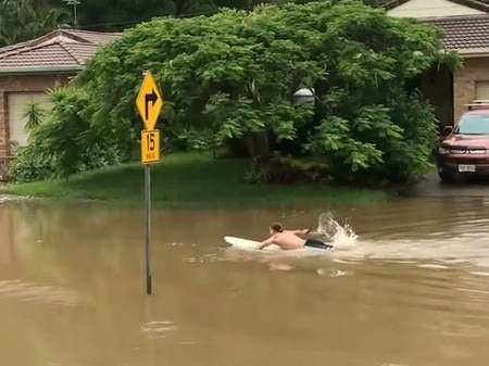 A Tweed local goes for a paddle in the rising waters.