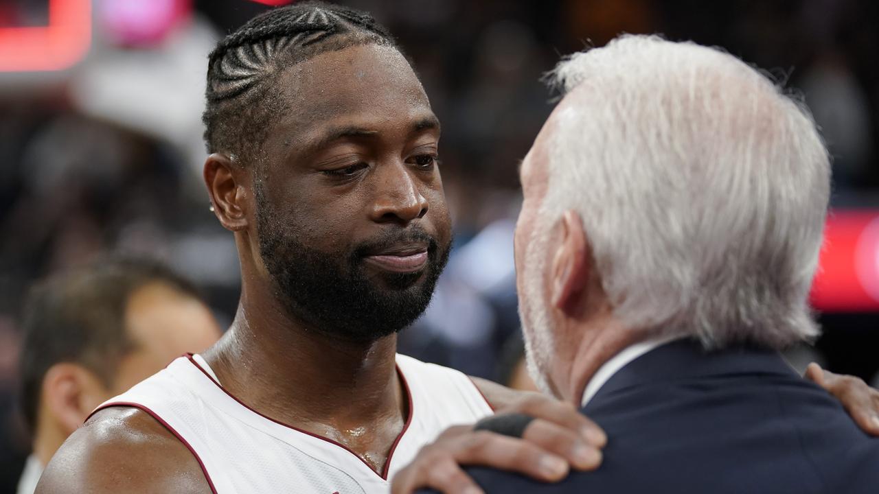 Miami Heat guard Dwyane Wade, left, embraces San Antonio Spurs coach Gregg Popovich.