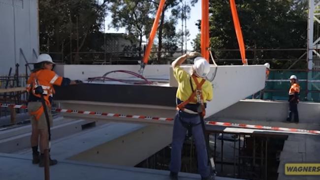 Workers steer one of Wagners' Earth Friendly Concrete blocks into place.