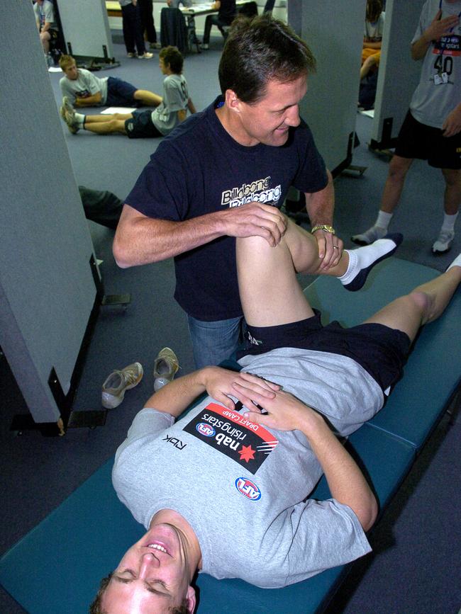 Sydney Swans doctor Nathan Gibbs looks at Joel Selwood at the NAB AFL Draft Camp at the AIS in Canberra.