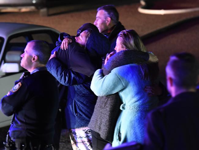 Shocked neighbours gather outside the house fire. Picture: Gordon McComiskie