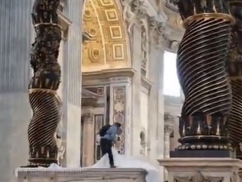 Mobile phone footage circulating on social media showed a man standing on the altar under the towering Baldachin canopy, kicking off the candelabra and then removing the white altar cloth before officers stepped in. Picture: X